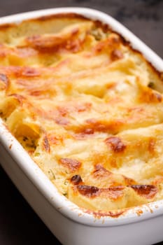 Cannelloni gratin filled with cheese in vertical format