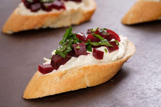 Bruschetta with farmers cheese horseraddish beetroot and parsley in back lit