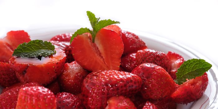 Red strawberries with green mint in back lit
