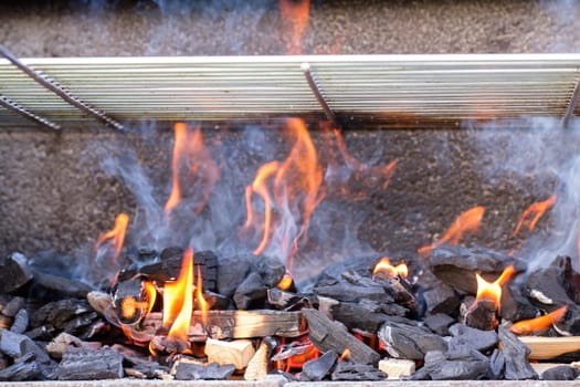 Fire flames smoke charcoal in a grill with grid