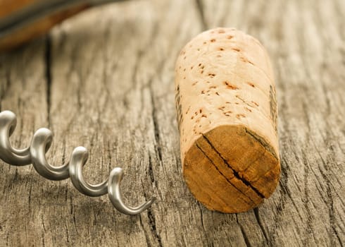 Cork and spindle of a corkscrew close-up on wooden board