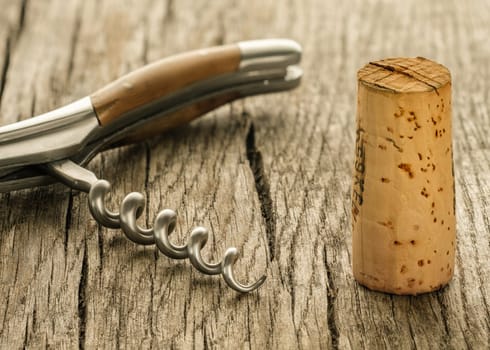 Wine cork and spindle of a corkscrew on rustic wood