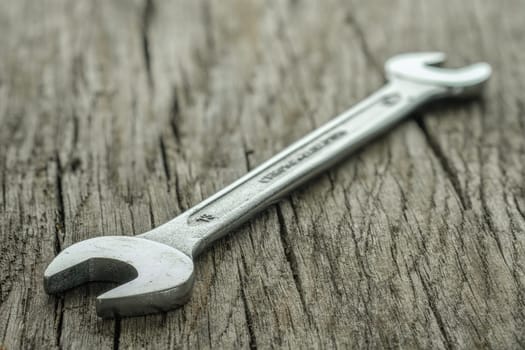 Chrome Vanadium steel wrench on rustic wooden board
