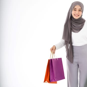 Closeup Confident happy smiling female muslim woman with shopping bag. Studio shot on white background. Using for sale consumerism and shopaholic concept.