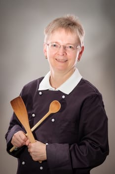 Female chef smiling with wooden cooking spoon