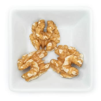 Walnuts in a white square bowl in top view