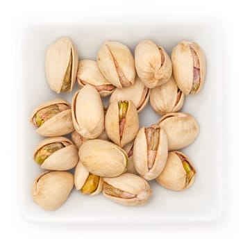 Pistachios with shell salted in a bowl in top view