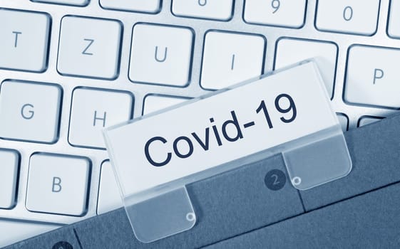 Covid-19 binder on computer keyboard in the office