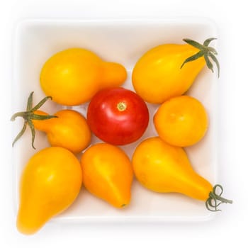 Red and yellow cherry tomatoes in a bowl in top view