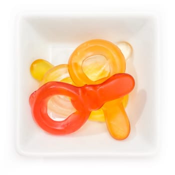Gum dummy pacifier in a white bowl in top view