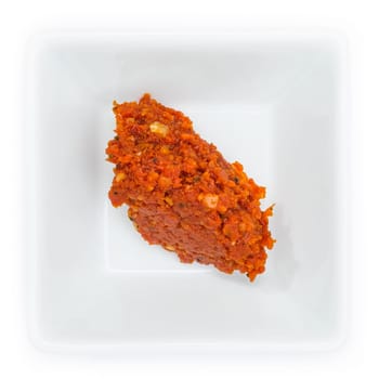 Red hot chili paste in a white bowl ceramic in top view