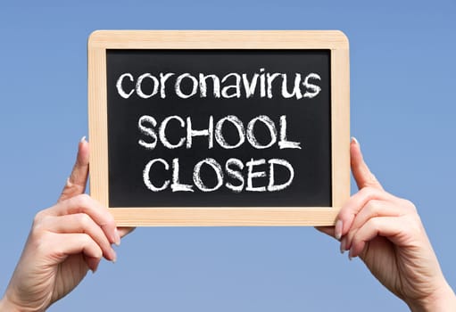 Coronavirus, school closed, female hands with chalkboard