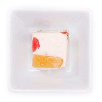 White nougat with candied fruits in a bowl in top view