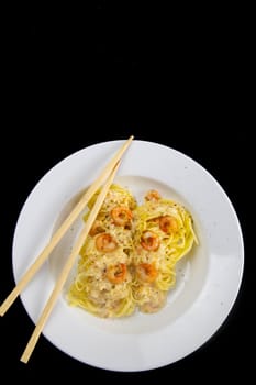 Spaghetti shrimp in white dish, top view noodles spicy with seafood isolated on black background - Clipping Path, Top views.