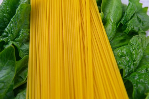Creative layout made of spinach and noodles on white wooden background. Flat lay. Food concept. Macro concept.