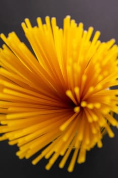 Yellow long spaghetti on a dark background. Top views