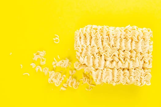 Instant noodles with wood sticks. Asian fast food on a yellow background close-up. Top views.