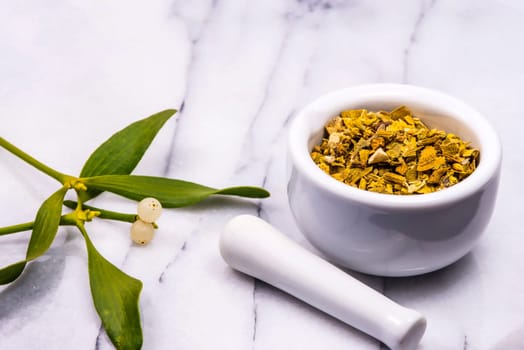 mistletoe, medicinal herb dried and fresh leaves with mortar