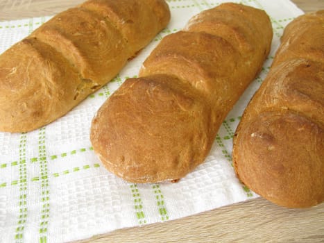 Freshly baked baguette on a dishtowel