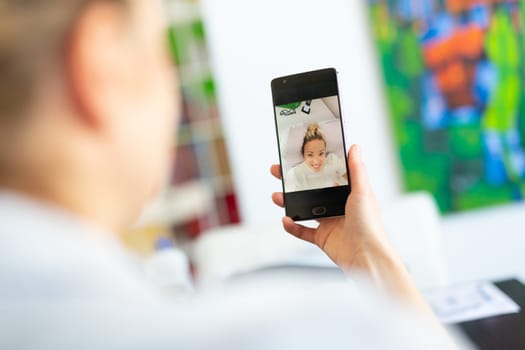Stay at home, social distancing lifestyle. Woman at home using social media on phone for video chatting with her loved ones during corona virus pandemic.