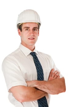 Slight side upper body view of a young man with crossed arms, white shirt, tie and white construction site helmet looking friendly at the camera against white background.