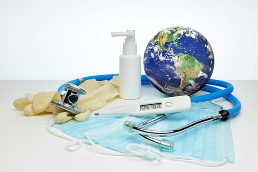 COVID-19. World globe with stethoscope, medical masks, sanitizer, thermometer on white background. Global quarantine, infection prevention, coronavirus. Elements of this image furnished by NASA