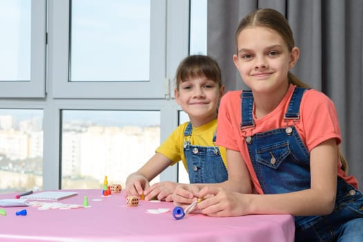 Two girlfriends play board games for children and looked at the frame