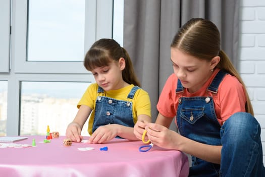 Two girls play games at the table