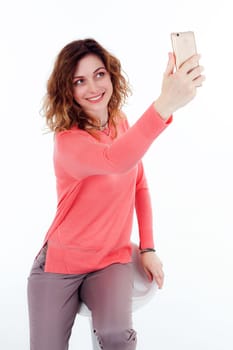 Portrait of cute joyful woman with trendy hairstyle wearing basic t-shirt talking on mobile phone isolated over white background.