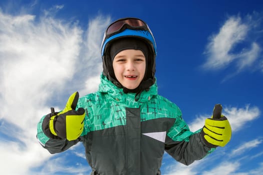 little boy on mountains in ski helmet with fallen first tooth, Czech Republic