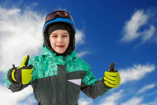 little boy on mountains in ski helmet with fallen first tooth, Czech Republic