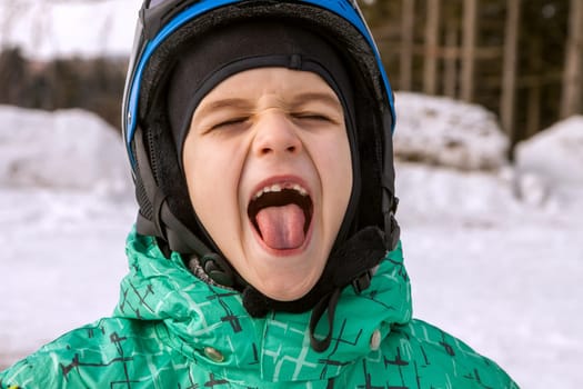 little boy on mountains in ski helmet with fallen first tooth, Czech Republic
