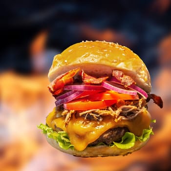 Close-up of home made burgers with fire flames and black background