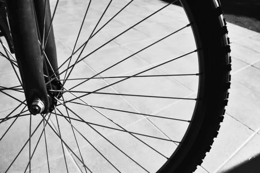 The front tyre of a bicycle in grayscale