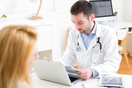 View of a Young attractive doctor listening his patient