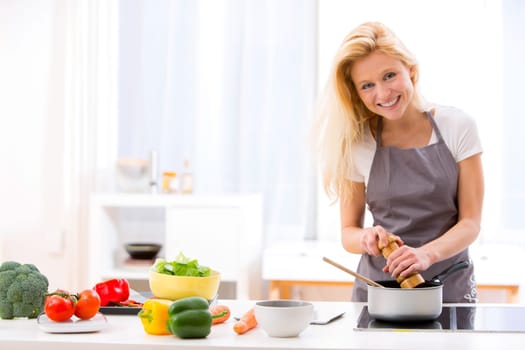 View of a Young attractive woman cooking in a kitchen