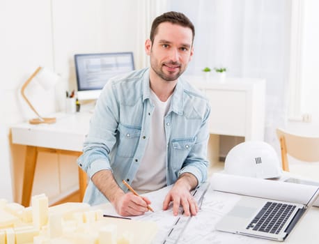 View of a Young attractive architect working at the office