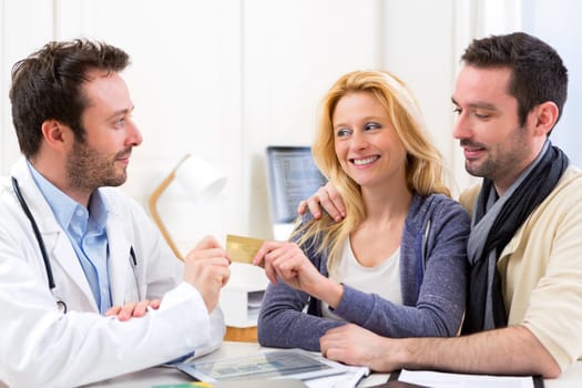 View of a Young attractive couple paying consultation to the doctor