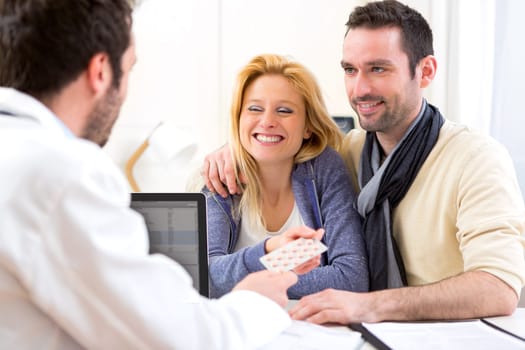 View of a Doctor gives pills to couple of patient