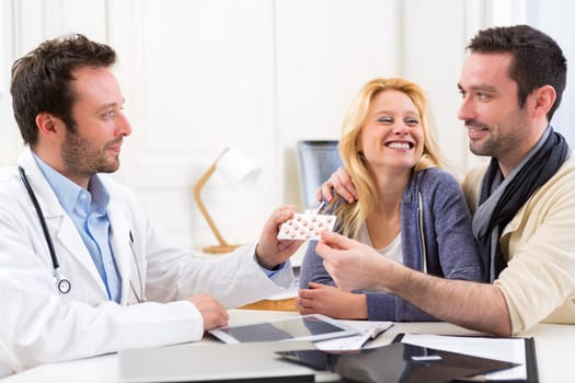 View of a Doctor gives pills to couple of patient