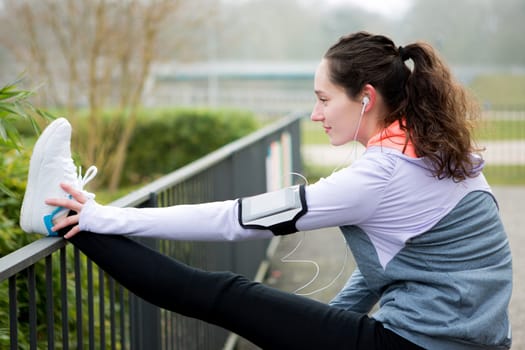 View of a Young attractive woman stretching after a running session