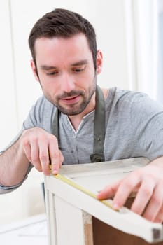 View of a Young attractive carpenter working in his workshop