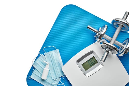 Sport equipment, scales, medical masks and sanitizer on white background. Top view, copy space. Fitness.  Isplation period. Weight and health control during quarantine. Concept of covid or coronavirus