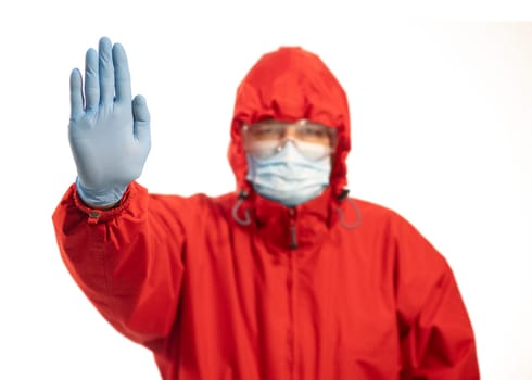 Person with mask and hand raised in red protective suit, stop concept for social distancing