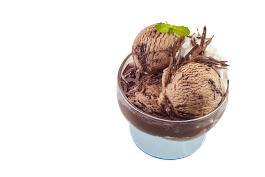 Delicious chocolate ice cream with flakes and fresh mint in a glass pedestal bowl in a high angle view isolated on white with copy space