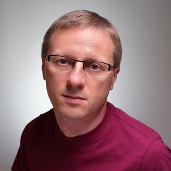Caucasian man with glasses and serious glimpse grey background