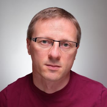 Frontal portrait man with glasses background grey