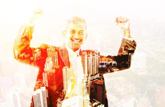 Double exposure image of excited business man celebrating success overlay with cityscape.