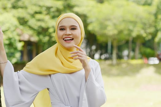 Portrait of cheerful Muslim girl in hijab, smiling at outdoor.