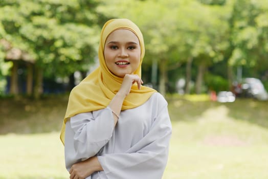 Portrait of cheerful Muslim girl in hijab, smiling at outdoor.